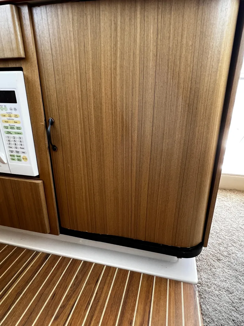 Slide: The Image of 2001 Bayliner 3488 Command Bridge Motoryacht interior with wood paneling and microwave. - 34