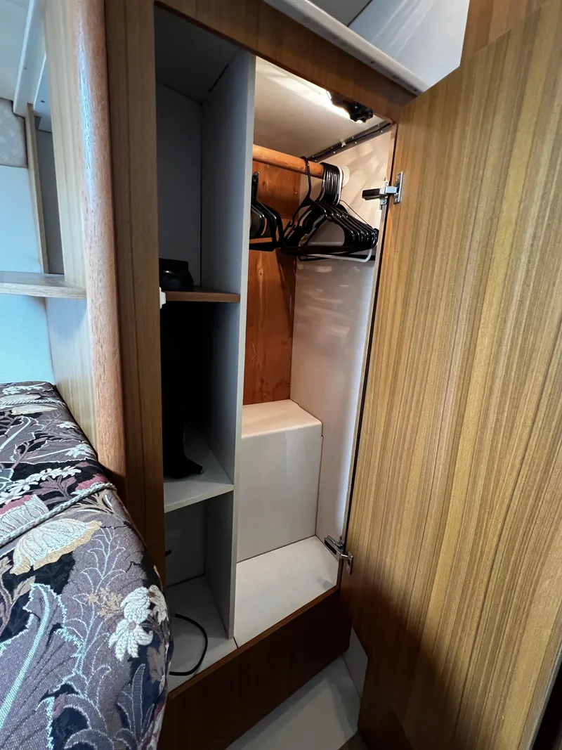 Slide: The Image of 2001 Bayliner 3488 Command Bridge Motoryacht interior closet with hangers and wooden finish. - 43