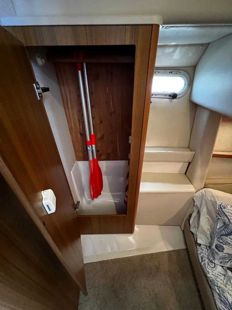 Slide: The Image of 2001 Bayliner 3488 Command Bridge Motoryacht interior with open wooden cabinet and stored paddles. - 48