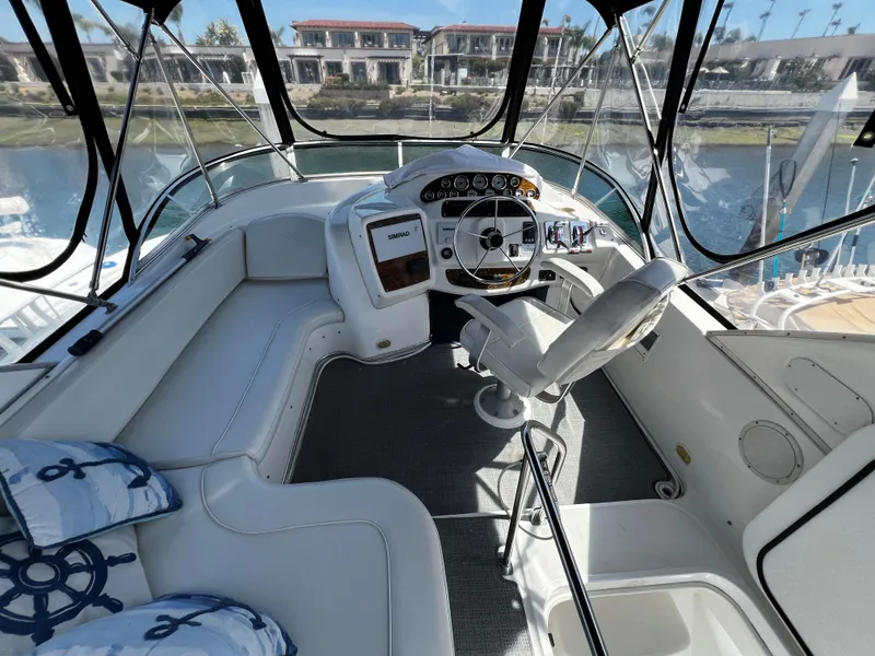 Slide: The Image of 2001 Bayliner 3488 Command Bridge Motoryacht cockpit with steering wheel and seating, dockside view. - 6