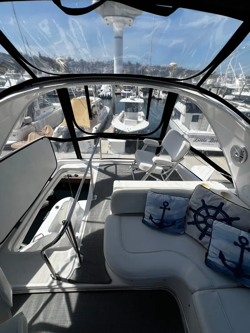 Slide: The Image of 2001 Bayliner 3488 Command Bridge Motoryacht interior with nautical-themed cushions, docked at marina. - 8