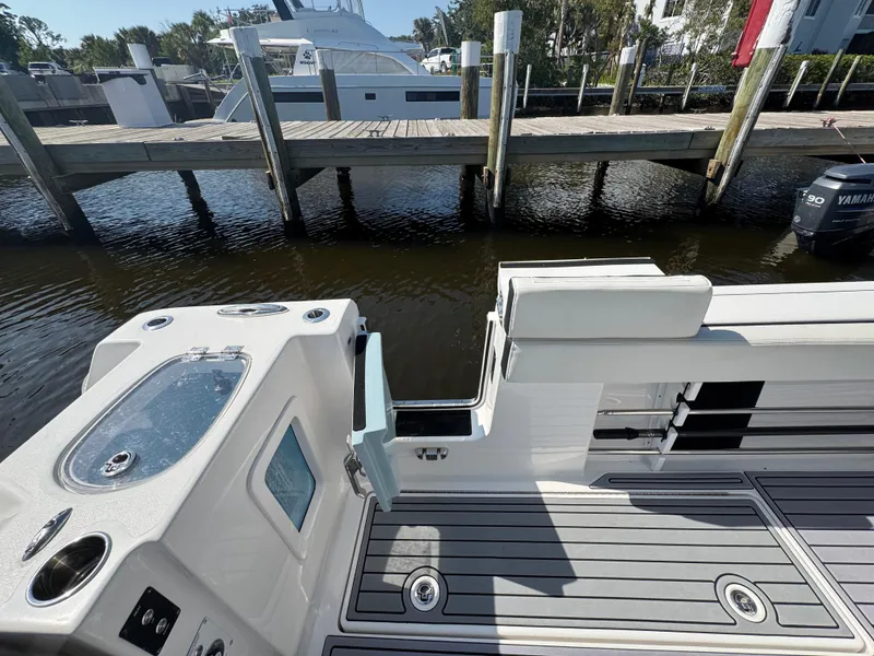 Slide: The Image of 2024 Tidewater 380 CC Adventure boat with sleek deck design and dockside view. - 11