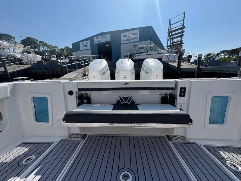 Slide: The Image of 2024 Tidewater 380 CC Adventure boat with triple engines at a marina. - 18