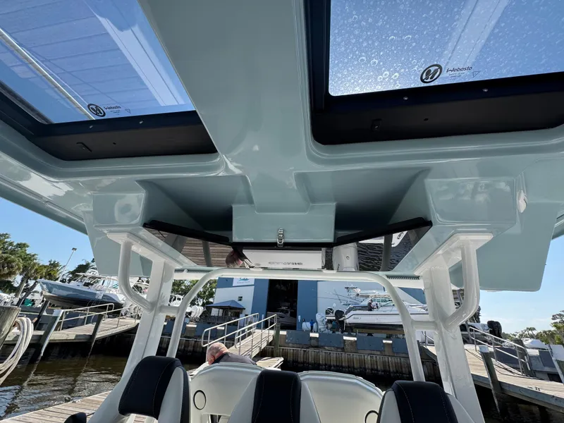 Slide: The Image of 2024 Tidewater 380 CC Adventure boat interior with skylights and seating at a marina. - 20