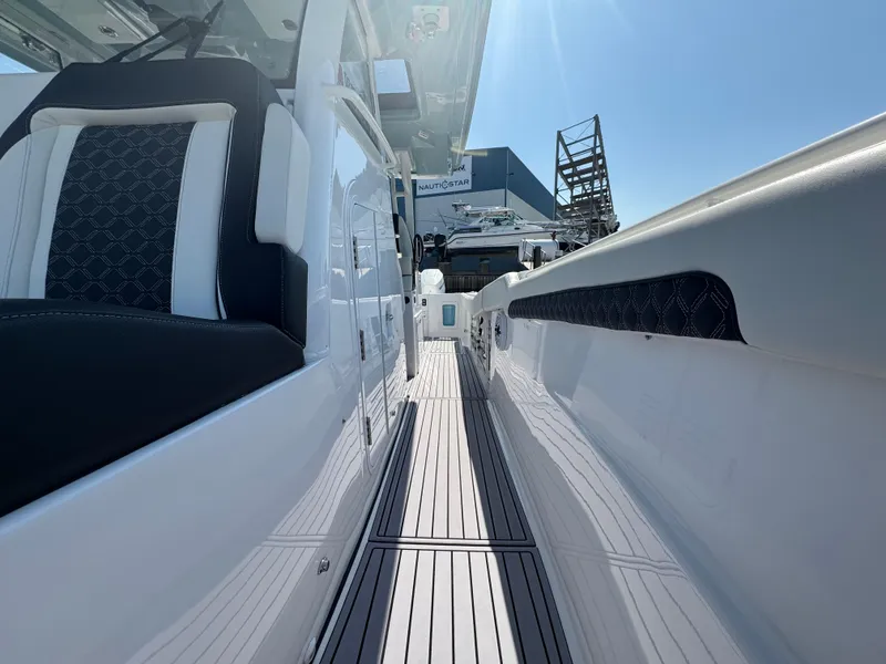 Slide: The Image of 2024 Tidewater 380 CC Adventure boat, sleek design, spacious deck, modern seating, sunny day. - 24