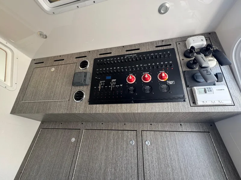 Slide: The Image of Control panel of 2024 Tidewater 380 CC Adventure boat, featuring switches and gauges. - 27