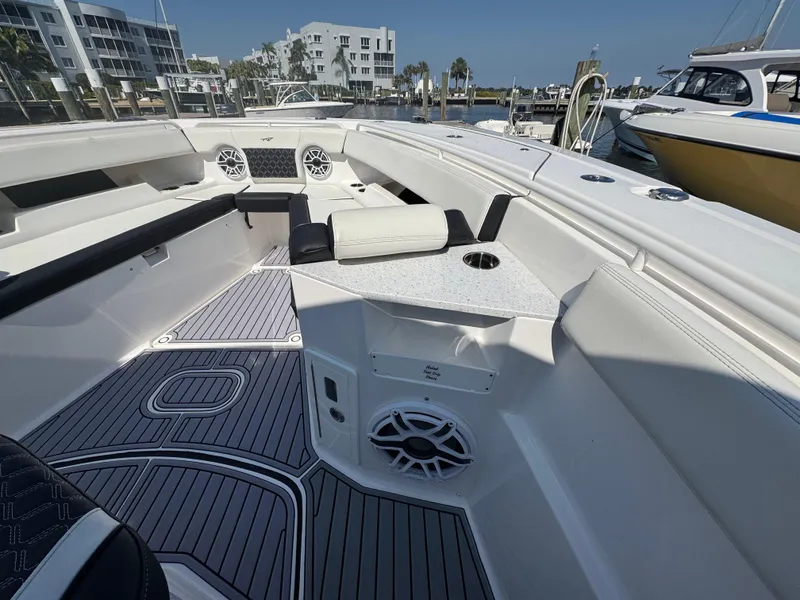 Slide: The Image of 2024 Tidewater 380 CC Adventure boat interior with seating and speakers at a marina. - 34