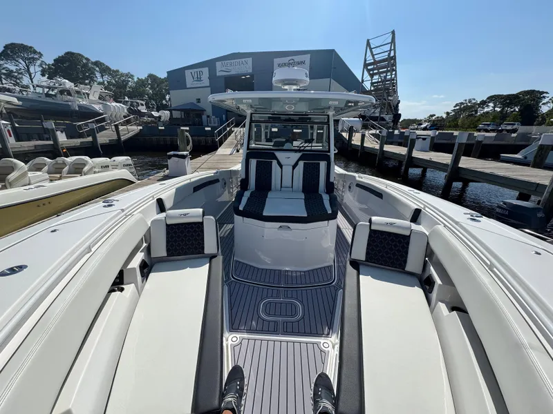 Slide: The Image of 2024 Tidewater 380 CC Adventure boat docked at marina, showcasing spacious seating and sleek design. - 39