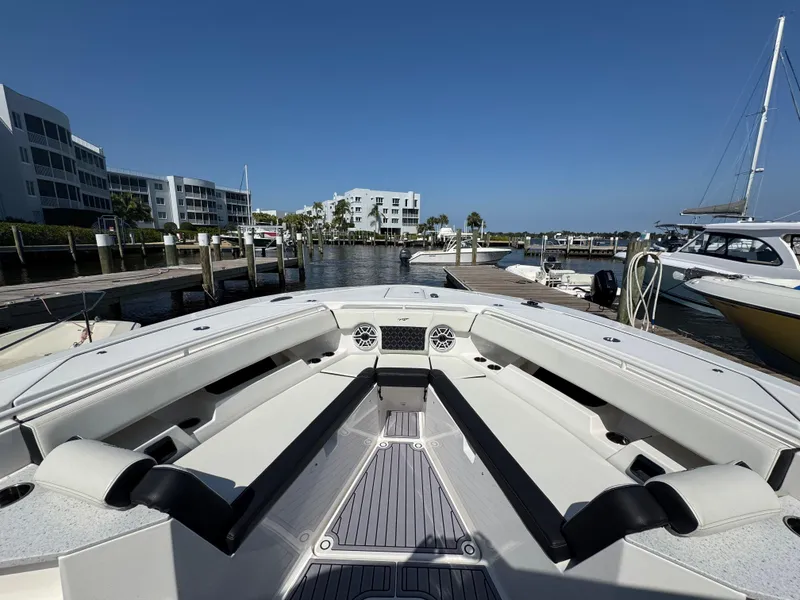 Slide: The Image of 2024 Tidewater 380 CC Adventure boat docked at marina, showcasing spacious seating and modern design. - 41