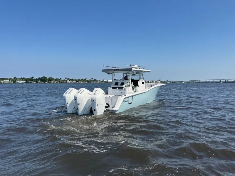 Slide: The Image of 2024 Tidewater 380 CC Adventure boat cruising on open water with triple engines. - 43