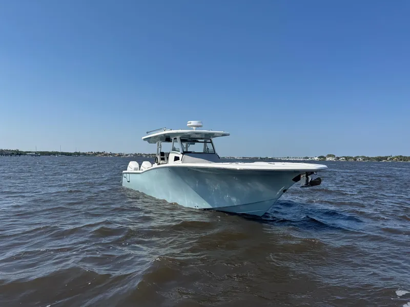 Slide: The Image of 2024 Tidewater 380 CC Adventure boat on open water under clear blue sky. - 48