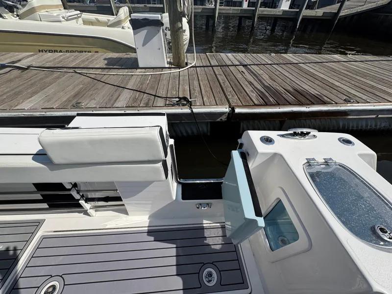 Slide: The Image of 2024 Tidewater 380 CC Adventure boat docked, featuring sleek deck design and seating area. - 9