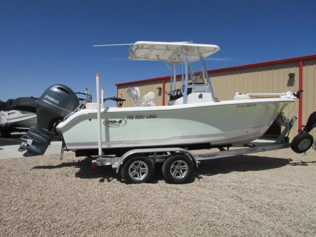 Slide: The Image of 2021 Sea Hunt 219 Ultra boat on trailer, parked outdoors, featuring Yamaha outboard motor. - 1