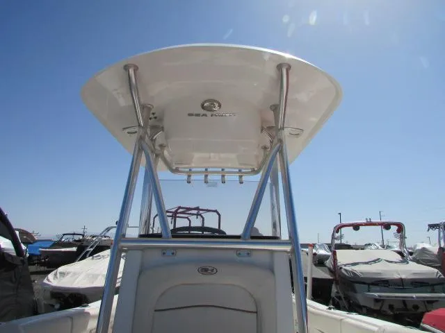 Slide: The Image of 2021 Sea Hunt 219 Ultra boat with T-top, docked under clear blue sky. - 21