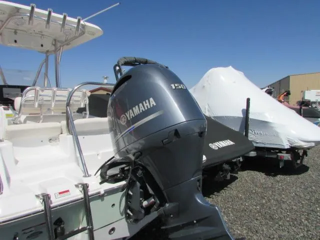 Slide: The Image of 2021 Sea Hunt 219 Ultra boat with Yamaha 150 outboard motor, parked outdoors. - 24