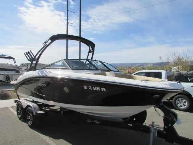 Slide: The Image of 2023 Sea Ray 190 Sport boat on trailer, parked outdoors under a clear sky. - 3