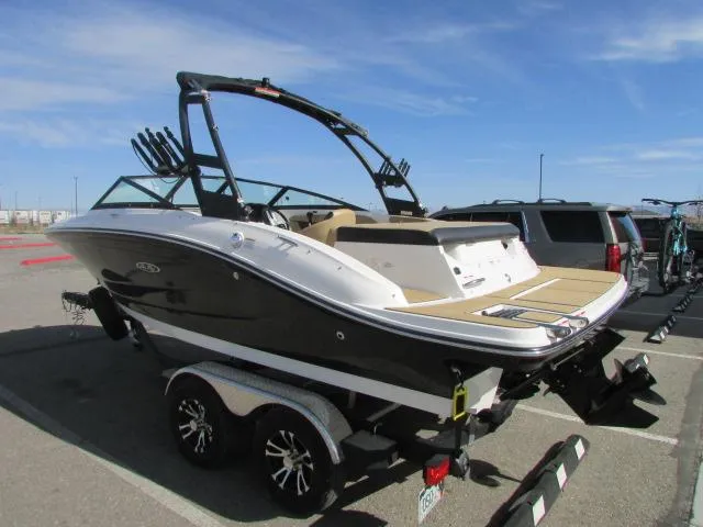 Slide: The Image of 2023 Sea Ray 190 Sport boat on trailer in parking lot under clear sky. - 7