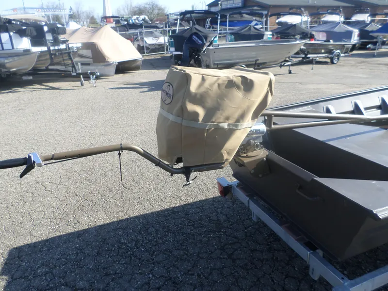 Slide: The Image of 2025 Alweld 1542 Jon boat with covered motor on trailer in a boatyard. - 7