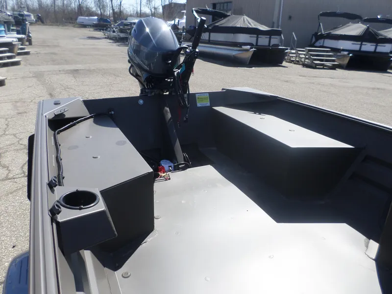 Slide: The Image of 2025 Alweld 1548 VV Marsh Tiller boat interior with motor, docked outdoors. - 3