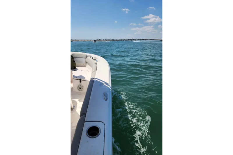 Slide: The Image of 2022 Sea Fox 228 Commander boat cruising on clear blue water under a sunny sky. - 15