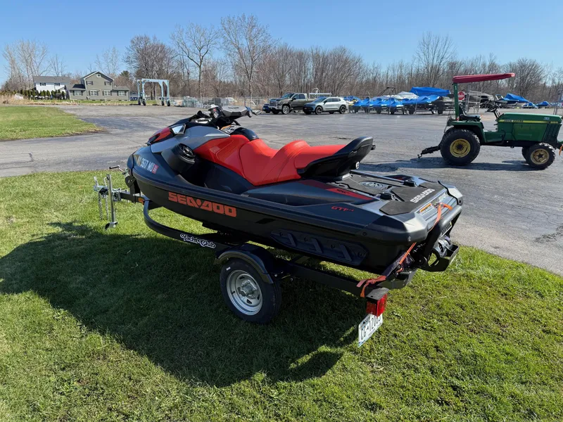 Slide: The Image of 2023 Sea-Doo GTI SE 130 with BRP Premium Audio on trailer, parked on grass. - 3