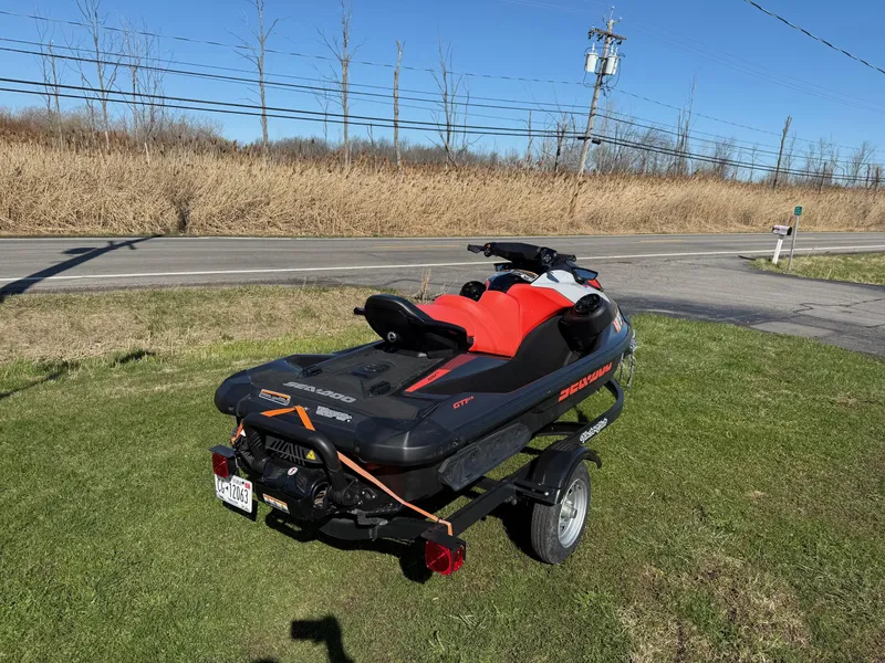 Slide: The Image of 2023 Sea-Doo GTI SE 130 with BRP Premium Audio on trailer, parked on grass. - 6