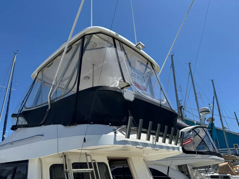 Slide: The Image of 2003 Mediterranean 38 Convertible yacht with enclosed flybridge, docked under clear blue sky. - 11