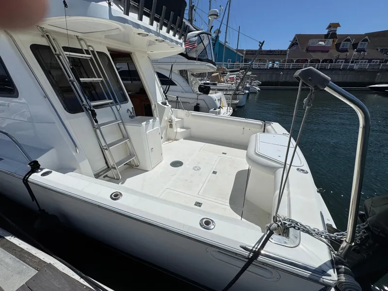 Slide: The Image of 2003 Mediterranean 38 Convertible yacht docked at marina, featuring spacious deck and sleek design. - 12