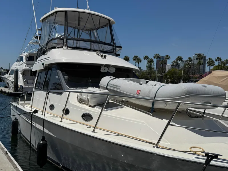 Slide: The Image of 2003 Mediterranean 38 Convertible yacht docked with inflatable boat on deck. - 129