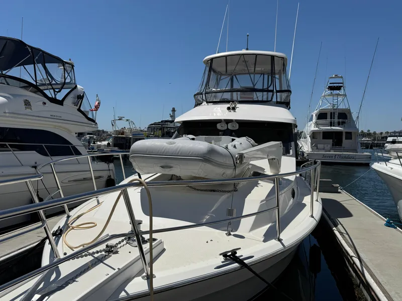 Slide: The Image of 2003 Mediterranean 38 Convertible yacht docked at marina with inflatable boat on deck. - 130