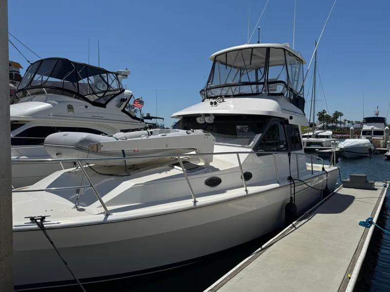 Slide: The Image of 2003 Mediterranean 38 Convertible yacht docked at marina under clear blue sky. - 131