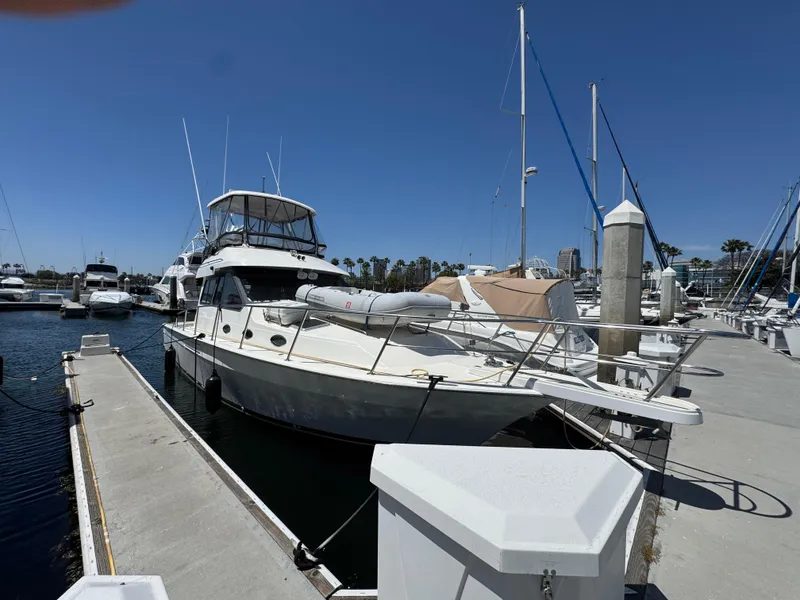 Slide: The Image of 2003 Mediterranean 38 Convertible yacht docked at marina under clear blue sky. - 132