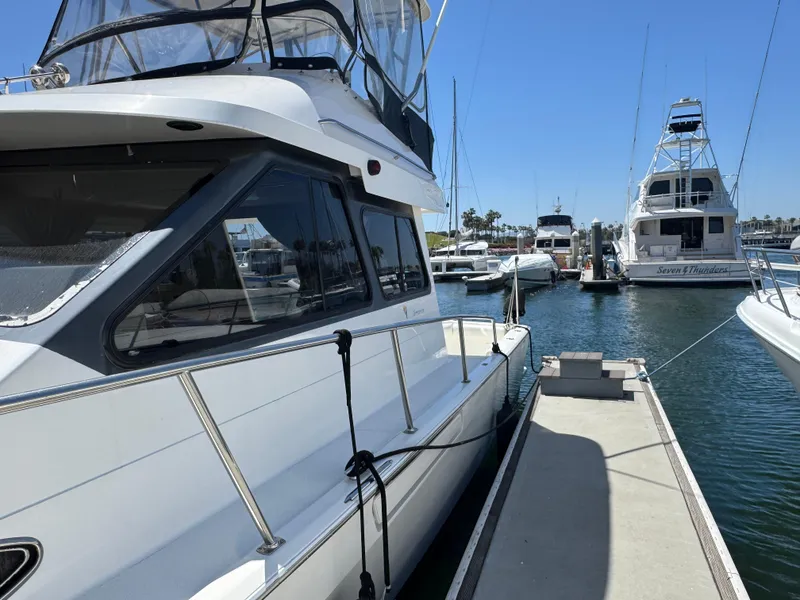 Slide: The Image of 2003 Mediterranean 38 Convertible yacht docked at marina under clear blue sky. - 17