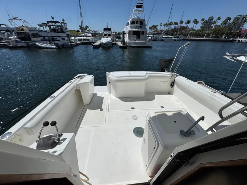 Slide: The Image of 2003 Mediterranean 38 Convertible yacht docked in a marina, featuring a spacious deck area. - 27