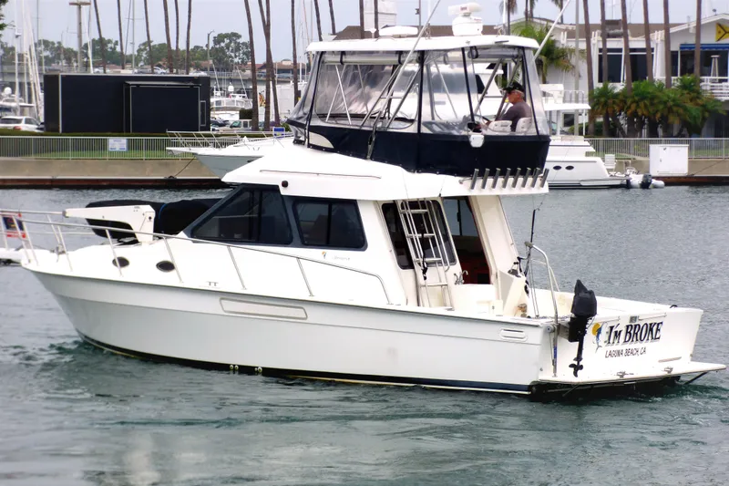 Slide: The Image of 2003 Mediterranean 38 Convertible yacht named "I'm Broke" in a marina setting. - 3