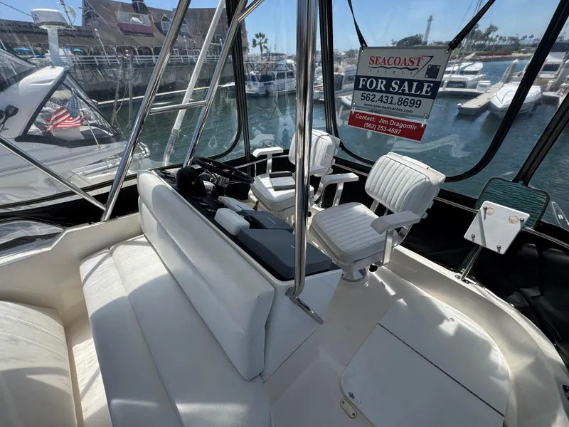Slide: The Image of 2003 Mediterranean 38 Convertible yacht interior with seating, for sale sign visible. - 48