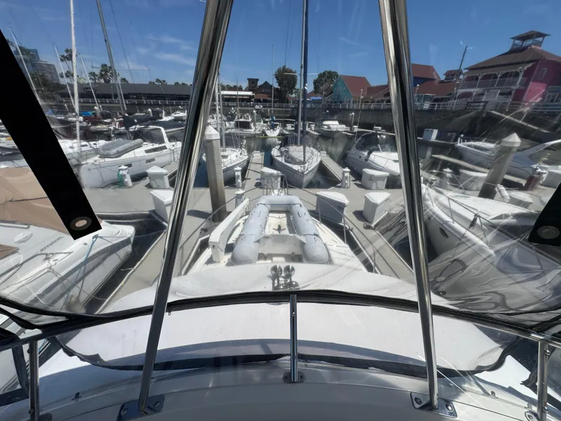 Slide: The Image of View from 2003 Mediterranean 38 Convertible yacht in marina, surrounded by boats and clear skies. - 51