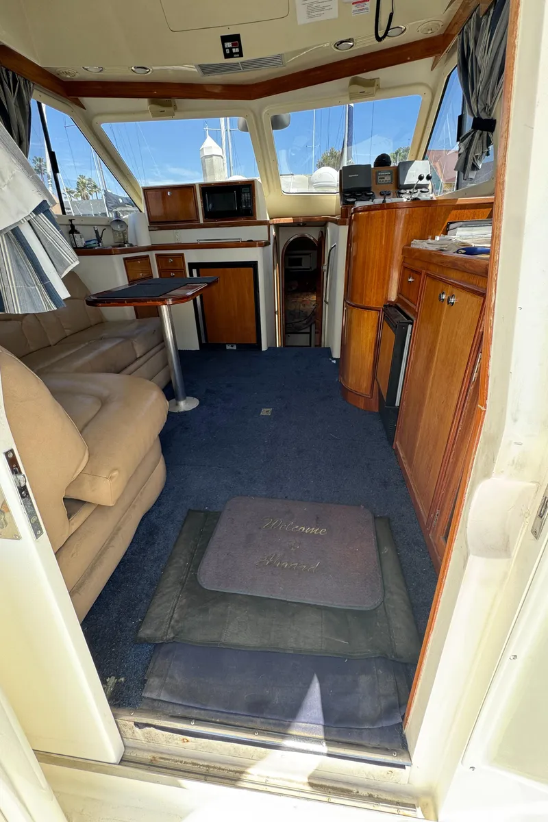 Slide: The Image of Interior of 2003 Mediterranean 38 Convertible yacht with cozy seating and wooden cabinetry. - 52