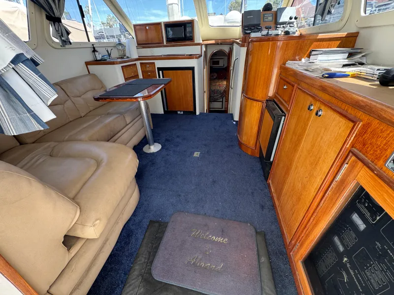 Slide: The Image of Interior of 2003 Mediterranean 38 Convertible yacht with plush seating and wooden cabinetry. - 53