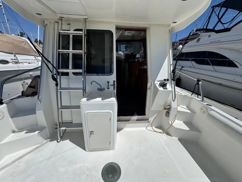 Slide: The Image of 2003 Mediterranean 38 Convertible yacht deck with ladder and sink, docked at marina. - 8