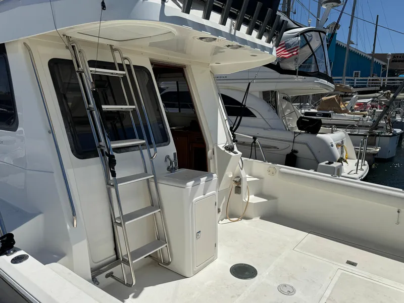 Slide: The Image of 2003 Mediterranean 38 Convertible yacht with ladder and deck, docked at marina. - 9