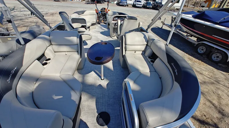 Slide: The Image of 2022 South Bay 200 Series S222RS pontoon boat with spacious seating and central table. - 10