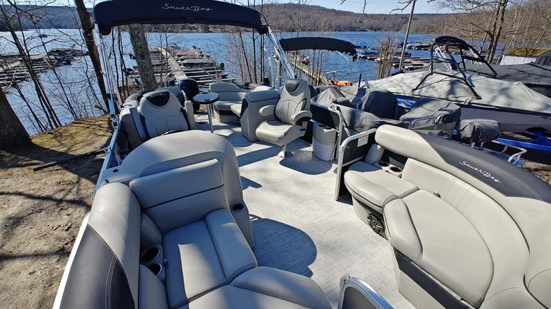 Slide: The Image of 2022 South Bay 200 Series S222RS pontoon boat with spacious seating, docked by a scenic lake. - 13