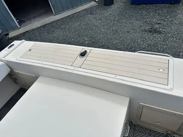 Slide: The Image of 2001 Parker 2510DVWA boat deck with storage compartments, shown in a marina setting. - 17