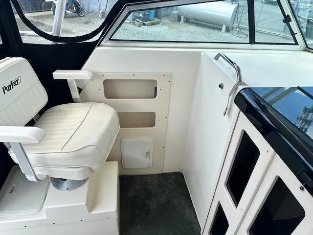 Slide: The Image of Interior of a 2001 Parker 2510DVWA boat with white seating and dashboard. - 6