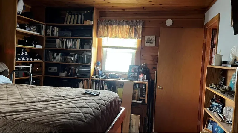 Slide: The Image of Cozy houseboat bedroom with wooden shelves, books, and a window. Custom model, 1990. - 12