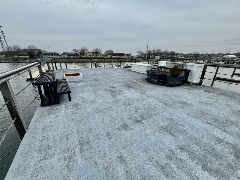 Slide: The Image of Rooftop view of a 1990 custom houseboat with benches and potted plants. - 5