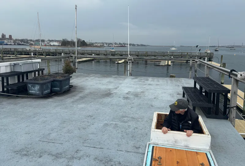 Slide: The Image of Man emerging from hatch on 1990 custom houseboat deck, overlooking marina with boats and docks. - 6