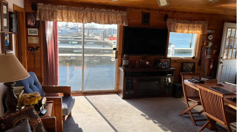 Slide: The Image of Cozy 1990 custom houseboat interior with waterfront view, wooden decor, and comfortable seating. - 9