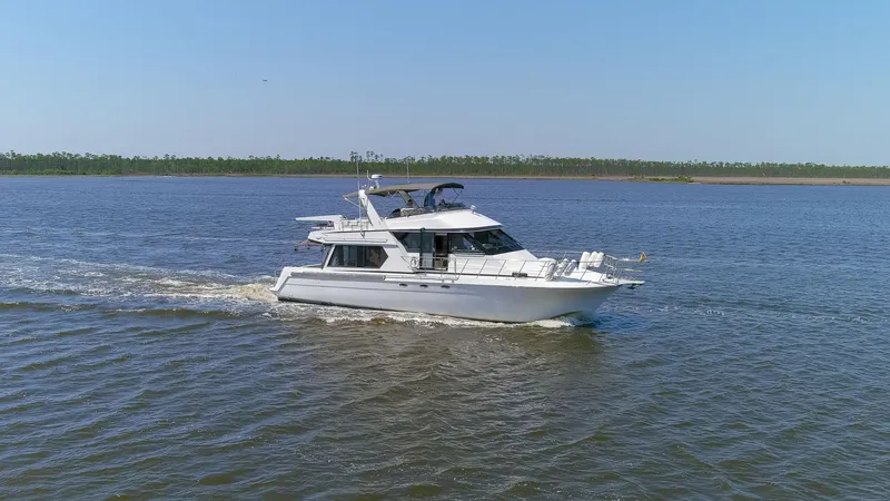 Slide: The Image of 1997 Navigator 5600 Sundance Pilothouse yacht cruising on a calm river. - 25